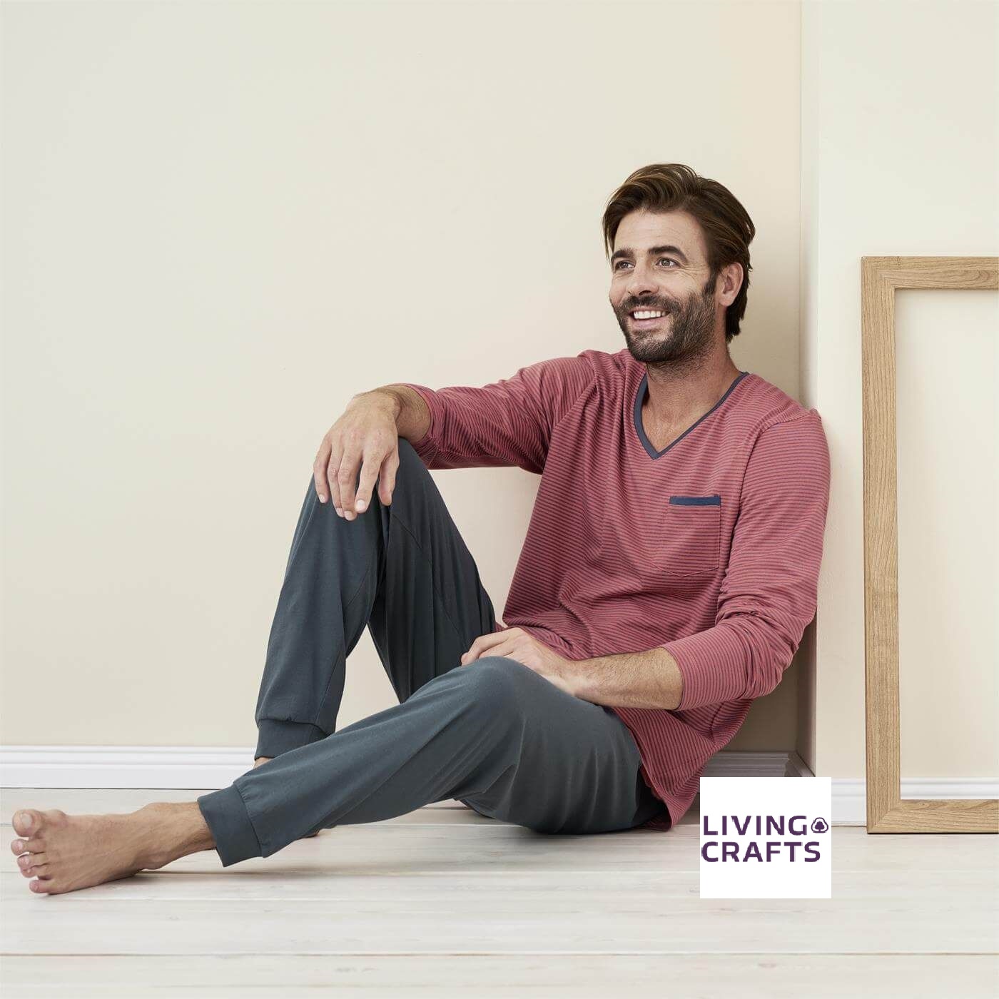 Entdecke Deinen Herren Schlafanzug bei uns im Online Shop. Bio & nachhaltig kaufen. Ein Mann sitzt auf dem Boden. Er traägt einen nachhalitigen Herren Schlafanzug aus Bio Baumwolle, den ihr bei uns online bestellen könnt.