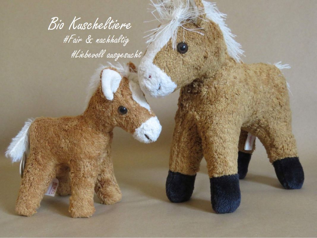 Zwei Kuscheltiere aus Bio Baumwolle stehen nebeneinander - ein Fohlen und ein Pferd